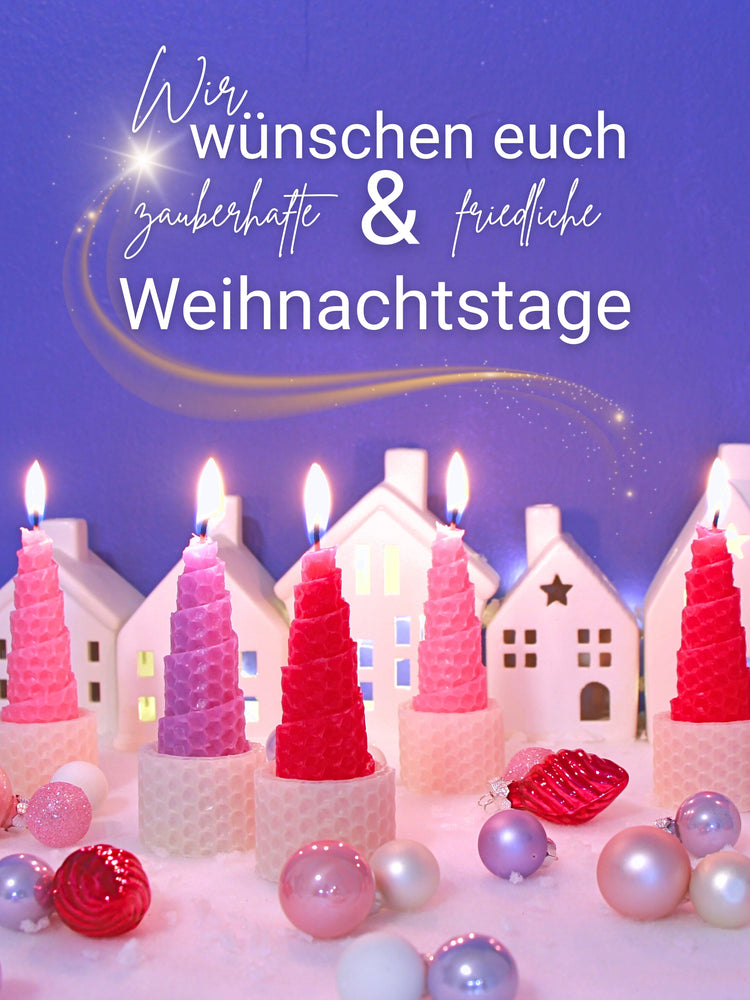 Wir wünschen euch zauberhafte und friedliche Weihnachten. Zu sehen ist eine kleine Winterlandschaft mit kleinen Christbaumkugeln und im Vordergrund stehen 6 Bienenwachskerzen die wie Weihnachtsmüztzen aussehen.